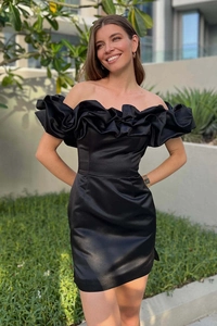 Détail de la robe satinée noire avec décolleté à volants et design épaules dénudées