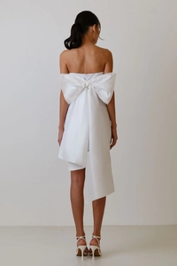 Rear view of white strapless cocktail dress featuring a large dramatic back bow and long tail