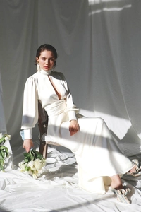 Detailed view of ivory satin dress with high neck cut-out design and puff lantern sleeves