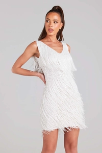 Détail de la robe courte blanche à paillettes avec des franges étagées et un col en V