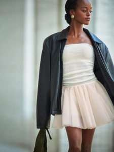 Detail of a chic layered tulle skirt paired with a black leather jacket and knit top