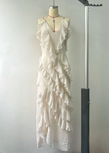 Detailed view of layered ruffles and sheer fabric on a white V-neck maxi dress