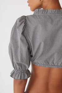Détail des manches bouffantes et de l'ourlet à volants sur crop top vichy