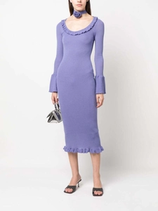 Détail de la robe en tricot lilas montrant l'ourlet à volants et les manches évasées