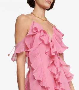 Detail of elegant pink dress featuring layered ruffles and a deep V-neckline design
