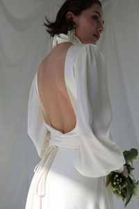 Detail of elegant backless satin evening gown with high neck and puffed lantern sleeves