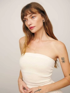Detail of off-white knit strapless bodice with ribbed texture and silver earrings