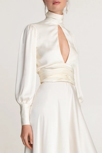 Macro detail of white satin dress featuring high neck, teardrop cutout and bubble sleeves