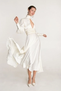 Detail of white satin dress featuring high neck cutout and elegant puffed sleeves