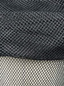Dettaglio di tessuto a rete glitterato con due densità di trama nera e filo argento