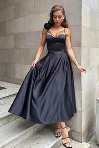 Dettaglio di abito da sera in raso nero con rosa 3D e top in stile corsetto