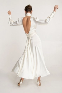 Macro detail of elegant backless satin gown with stand collar and sleek bow tie closure