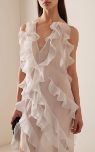 Detail of white semi-transparent dress with deep V-neckline and delicate lace trim