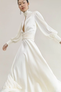 Detail of white satin evening gown featuring high neck, teardrop cutout, and lantern sleeves