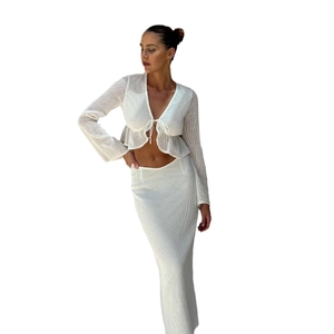 White crochet two-piece set featuring long sleeve wrap top and high waist slim skirt