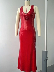 Detail of red sequin evening dress with handmade roses and a deep V-neckline on a mannequin