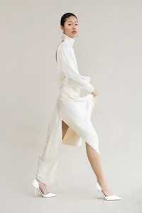 Detail of high neck satin maxi dress with bubble sleeves and side slit in white
