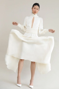 Detail of white satin dress featuring puffy sleeves and elegant front teardrop cutout
