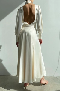 Detail of white satin evening dress featuring an open back design and waist tie ribbon