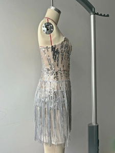 Close-up of silver sequined party dress with long fringe hem on a mannequin