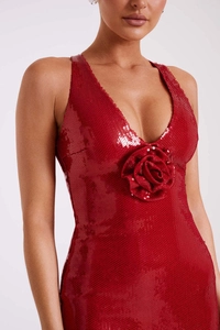 Detail of red sequin evening dress featuring deep V-neck and a 3D floral accent