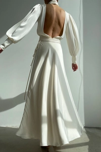 Detail of elegant white satin backless dress featuring lantern sleeves and waist tie