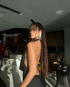 Close-up of elegant long white fringe tassel earrings with beads on a model in a backless dress