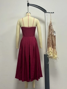 Détail de la robe maxi bordeaux ajustée avec jupe plissée et accessoire à gland à paillettes