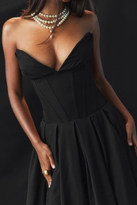 Détail du corsage avec armatures et jupe plissée de la robe de soirée noire élégante