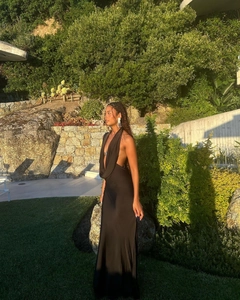 Close-up of black satin backless halter dress showing elegant deep V-neck and silky fabric