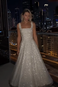 Gros plan sur le tissu pailleté étincelant de la robe de soirée blanche à bretelles