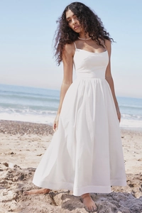 Detail of a white backless A-line midi dress with spaghetti straps and pleated waist