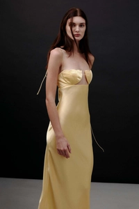 Detail eines eleganten champagnerfarbenen Satin-Kleids mit gewelltem Ausschnitt und Trägern
