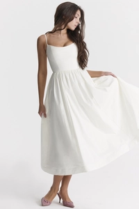 Detail of white sleeveless midi dress with thin straps and pleated waist on high heel shoes