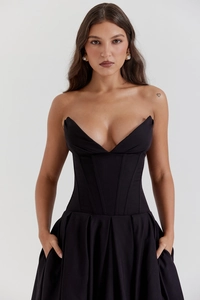Détails du décolleté en V profond et du corsage baleiné sur la robe de soirée noire