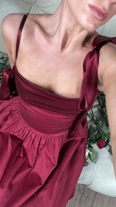 Detail of burgundy satin dress showing tie-up straps and pleated sweetheart neckline