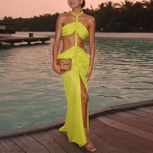 Detail of lime green halter dress featuring waist cut-out and high side slit