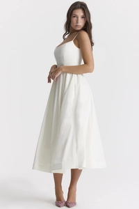Detail of white sleeveless A-line midi dress with spaghetti straps and side pockets