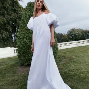 Robe longue blanche élégante à manches bouffantes et design dos nu long jusqu'au sol