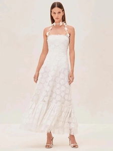 Detail of white lace halter dress featuring 3D floral accents and hollow petal embroidery