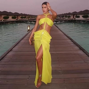 Detail of neon yellow chiffon dress with halter neck and side split on a boardwalk