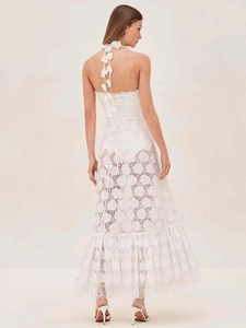 Detail of elegant white lace halter dress showing the backless design and floral embroidery