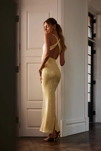 Detailed view of backless cross-strap design on a sequined pale yellow evening gown