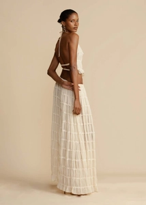 Detail of beige backless halter top and tiered chiffon maxi skirt with pleats