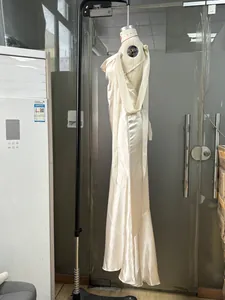 Dettaglio dell'elegante abito da sera in raso color champagne con scollo drappeggiato