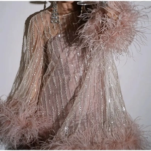 Pink sequin party dress featuring ostrich feather trim and elegant flared sleeves