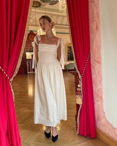 Detail of adjustable bow shoulder straps and pleated square neckline on ivory satin dress
