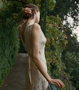 Detail of floral print dress featuring delicate white lace trim and backless lace-up design