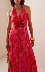 Detail of a large 3D rose and abstract floral print on a red and pink halter maxi dress