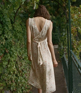 Detail of the backless floral midi dress featuring a romantic waist tie and deep V-neckline